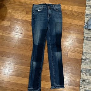J Brand skinny jeans with patch dye and frayed bottoms.
